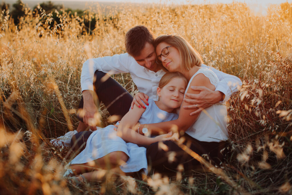 câlin collectif de parents et leur fille