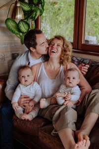 Photo des parents en leurs jumeaux sur le canapé en train de rigoler