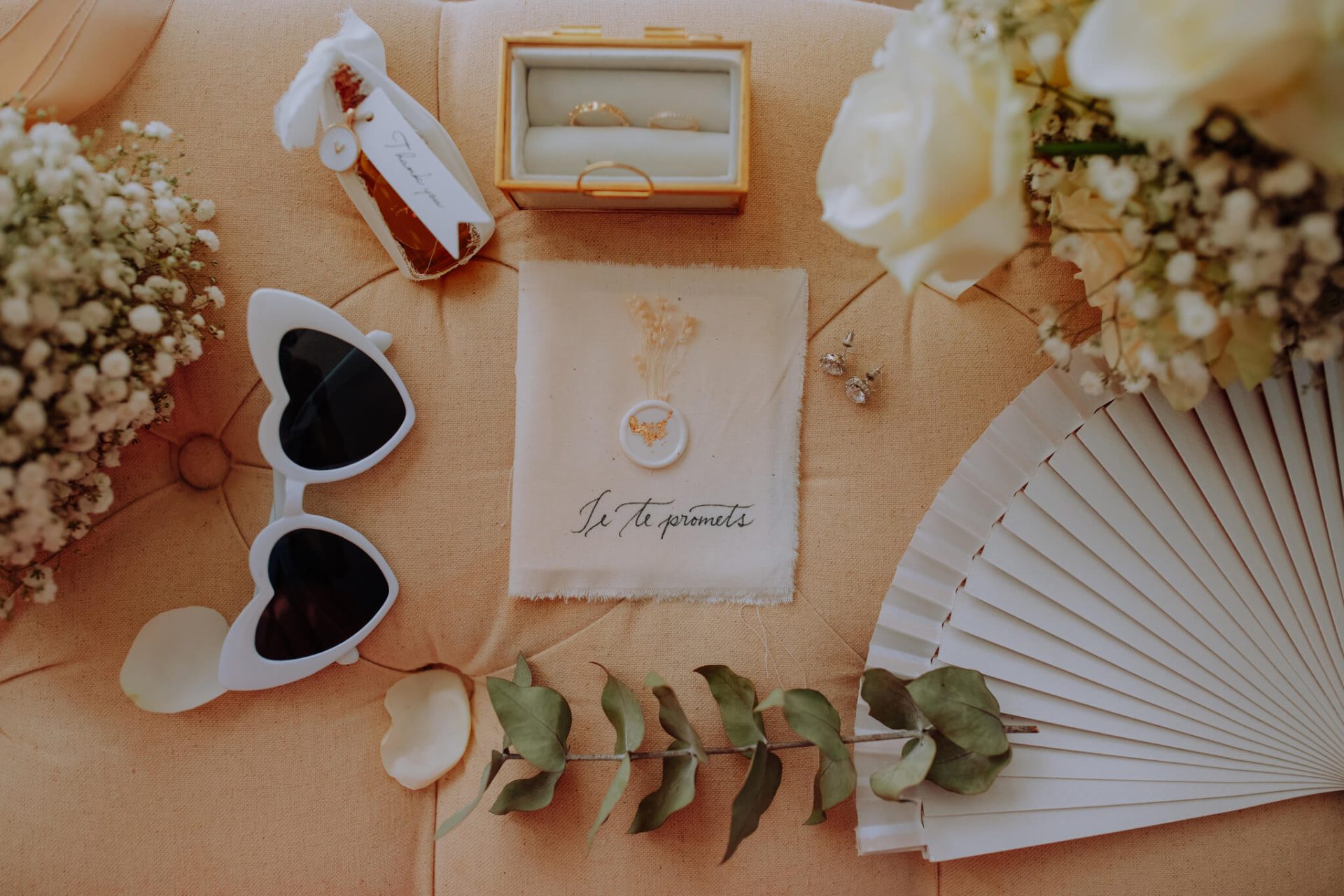 Image représentant un détail du mariage, comprenant un magnifique faire-part de mariage décoré de fleurs fraîches. Cette photo illustre l'élégance et la beauté des préparatifs pour une journée de mariage idéale